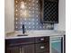 Basement wet bar with granite countertop, wine rack, and geometric tile at 729 Greenford N Trl, Carmel, IN 46032