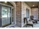 Brick front porch with wicker furniture and a glass door at 6275 Canak Dr, Avon, IN 46123