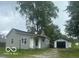 Ranch style home with gray siding and detached garage at 108 N Summit St, Summitville, IN 46070