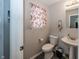 Clean bathroom with toilet, sink, and floral-print curtain at 4620 Whitham Ln, Indianapolis, IN 46237