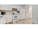 White kitchen with stainless steel appliances and laminate flooring at 7932 Eagle Valley Pass, Indianapolis, IN 46214