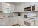 White kitchen with modern appliances and laminate flooring at 7932 Eagle Valley Pass, Indianapolis, IN 46214