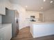 White kitchen with stainless steel appliances and hardwood floors at 231 Lar Lan Dr, Danville, IN 46122