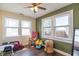 Playroom with hardwood floors, large windows, and a green accent wall at 532 E Mills Ave, Indianapolis, IN 46227