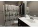 Clean bathroom with dark vanity and patterned shower curtain at 6611 Ventnor Pl, Indianapolis, IN 46217
