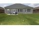 Brick home with backyard patio and grassy lawn at 6611 Ventnor Pl, Indianapolis, IN 46217
