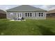 Brick home with backyard patio and grassy lawn at 6611 Ventnor Pl, Indianapolis, IN 46217