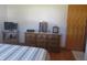 Simple bedroom with wood dresser, TV, and striped bedding at 610 W Monroe St, Alexandria, IN 46001