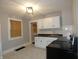 Renovated kitchen features white cabinets, tile backsplash, and new flooring at 305 Leeds Ave, Indianapolis, IN 46201