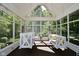 Relaxing screened porch with two white porch swings at 2838 Silverwood Ln, Greenwood, IN 46143