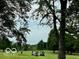 Golfers on a green with golf carts and trees at 980 Paris Dr, Franklin, IN 46131