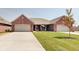 Brick duplex with attached two-car garages and a landscaped lawn at 2841 Grandview Ln, Greenwood, IN 46143