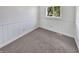 Simple bedroom with wood paneling, carpeting, and a window at 2647 Sheffield Dr, Indianapolis, IN 46229