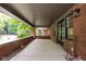 Covered front porch with brick flooring and view of a tree-lined street at 3860 N Delaware St, Indianapolis, IN 46205