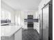 Modern white kitchen with stainless steel appliances and hexagon tile floor at 3860 N Delaware St, Indianapolis, IN 46205