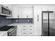Modern white kitchen with stainless steel appliances and hexagon tile floor at 3860 N Delaware St, Indianapolis, IN 46205