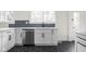 Modern white kitchen with stainless steel dishwasher and hexagon tile floor at 3860 N Delaware St, Indianapolis, IN 46205