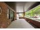 Covered front porch with brick flooring and view of a tree-lined street at 3860 N Delaware St, Indianapolis, IN 46205