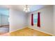 Simple dining area with hardwood floors and a window with red curtains at 709 Silver Fox Ct, Indianapolis, IN 46217