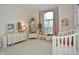 Charming bedroom with a crib, dresser, and a large arched window with pink curtains at 8850 Crystal Lake Dr, Indianapolis, IN 46240