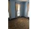 Bedroom with light blue walls, beige curtains, and brown carpet at 1804 N Delaware St, Indianapolis, IN 46202