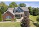 Brick two-story house with gray siding, landscaping, and pond view at 9259 Oak Knoll Ln, Fishers, IN 46037