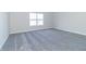 Empty bedroom with neutral gray carpeting and large window, ideal for customization at 6210 Fairview Dr, McCordsville, IN 46055