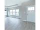 Empty living room with light gray walls, wood-look flooring, and large windows at 6210 Fairview Dr, McCordsville, IN 46055