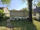 Home's backyard with grassy lawn and mature trees at 4050 Byram Ave, Indianapolis, IN 46208
