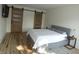Bright bedroom with wood floors and barn-style doors at 7419 Sylvan Ridge Rd, Indianapolis, IN 46240