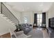 Living area with hardwood floors, gray sofa, and a cozy sitting area near window at 417 E Morris St, Indianapolis, IN 46225