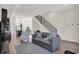 Open living room features hardwood floors, gray sofa, and a view into the kitchen at 417 E Morris St, Indianapolis, IN 46225