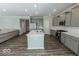 Open concept kitchen with island, gray cabinets, and hardwood floors at 10257 Meadow Path Ln, Indianapolis, IN 46239