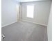 Spacious bedroom with grey carpet, window, and door to bathroom at 10257 Meadow Path Ln, Indianapolis, IN 46239