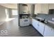 Kitchen features white cabinets, granite countertops, and a view into the living room at 905 Crescent Dr, Anderson, IN 46013