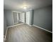 Spacious bedroom with gray walls, wood-look flooring, and access to hallway at 905 Crescent Dr, Anderson, IN 46013