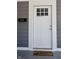 White front door with six-light window and welcome mat at 3131 Boulevard Pl, Indianapolis, IN 46208
