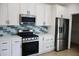 Modern kitchen with white cabinets, stainless steel appliances, and a stylish backsplash at 3131 Boulevard Pl, Indianapolis, IN 46208