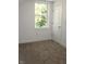 Simple bedroom with carpeted floor, window, and white door at 3131 Boulevard Pl, Indianapolis, IN 46208