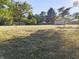 Sunny backyard with mature trees and distant shed at 108 W 650 South, Pendleton, IN 46064