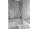Bathroom with gray tile, white vanity, and bathtub at 525 Schmitt Rd, Indianapolis, IN 46239