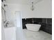 Spa-like bathroom with double vanity, free-standing tub, and black marble tile at 525 Schmitt Rd, Indianapolis, IN 46239