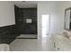 Modern bathroom with marble floors, black tile shower, and white vanity at 525 Schmitt Rd, Indianapolis, IN 46239