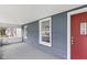 Inviting front porch with red door and gray siding at 1472 N Grant Ave, Indianapolis, IN 46201