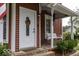 White front door on a red house with porch at 248 E Broadway St, Greenwood, IN 46143
