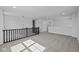 Open loft area with grey carpet and a railing at 10620 Banyan Wood Ct, Indianapolis, IN 46239