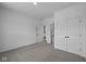 Bedroom with grey carpet, two doors, and a view of the kitchen at 10620 Banyan Wood Ct, Indianapolis, IN 46239