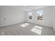 Bedroom with two large windows, grey carpet, and a door at 10620 Banyan Wood Ct, Indianapolis, IN 46239