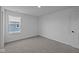Bright bedroom with grey carpet, large window, and neutral walls at 10620 Banyan Wood Ct, Indianapolis, IN 46239