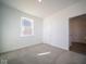 Well-lit bedroom with neutral carpeting and access to hallway at 7888 Magnolia St, New Palestine, IN 46163